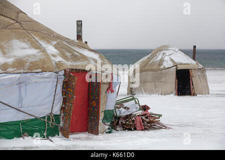 Jurten im traditionellen kirgisischen Jurtenlager während Schneesturm entlang des Song Kul / Song Kol Sees im Tian Shan Gebirge, Provinz Naryn, Kirgisistan Stockfoto