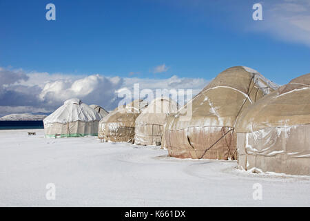Jurten im traditionellen kirgisischen Jurtenlager im Schnee entlang des Song Kul / Song Kol Sees im Tian Shan Gebirge, Provinz Naryn, Kirgisistan Stockfoto