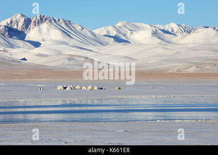 Jurten im traditionellen kirgisischen Jurtenlager im Schnee entlang des Song Kul / Song Kol Sees im Tian Shan Gebirge, Provinz Naryn, Kirgisistan Stockfoto