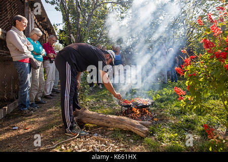 Kirgisische mann Kochen für Touristen auf einer traditionellen Stein Grill in Kirgisistan Stockfoto