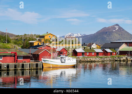 Boot vertäut im Hafen mit typisch norwegische Rorbu Hütten im Fischerdorf. Insel Vestvågøya Ballstad, Lofoten, Nordland, Norwegen Stockfoto