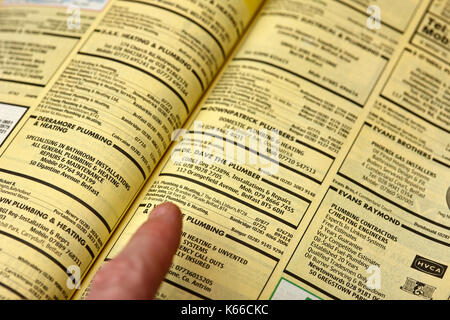 Mit dem Finger auf einzelne kleine Eintrag Business Listings in Gelbe Seiten, Telefonbuch Papier Ausgabe Großbritannien Stockfoto