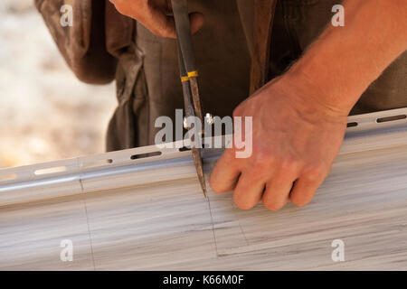 Ein Bauarbeiter durch Vinylabstellgleis mit heavy duty Schere in Ontario, Kanada. Stockfoto