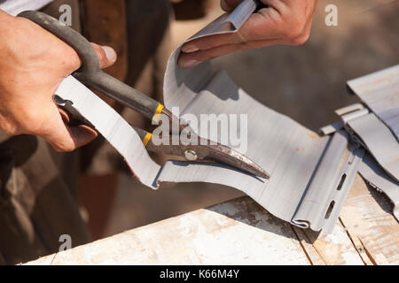 Ein Bauarbeiter durch Vinylabstellgleis mit heavy duty Schere in Ontario, Kanada. Stockfoto