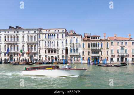 Wassertaxis und Gondeln auf dem Canal Grande, Venedig, Venetien, Italien vorbei vor der historischen Palazzi an einem sonnigen Sommertag Stockfoto