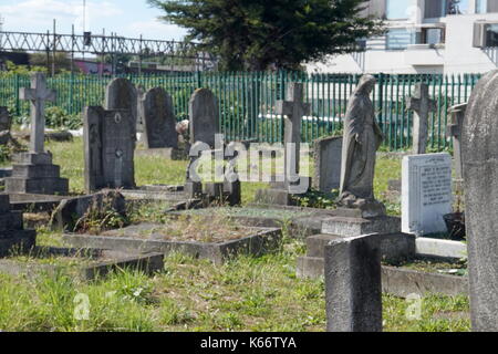 Gräber mit der Zaun um die Gleise an der Saint Mary's katholische Friedhof von Kensal Green, Harrow Road, London, Vereinigtes Königreich Stockfoto