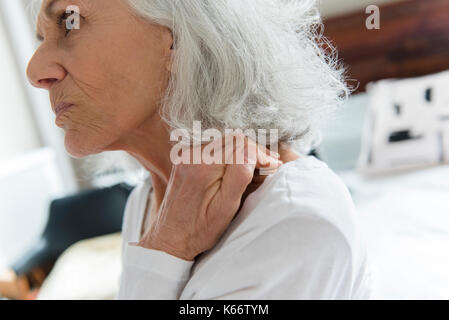 Ältere Frau Reiben der Hals Stockfoto