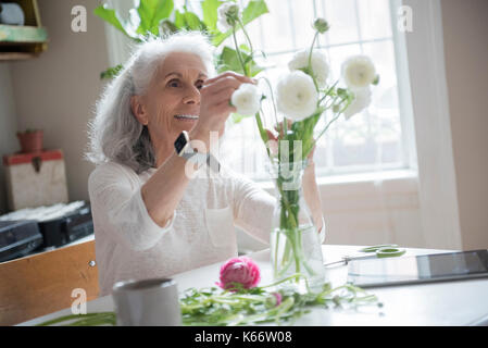 Ältere Frau Blumen arrangieren Stockfoto