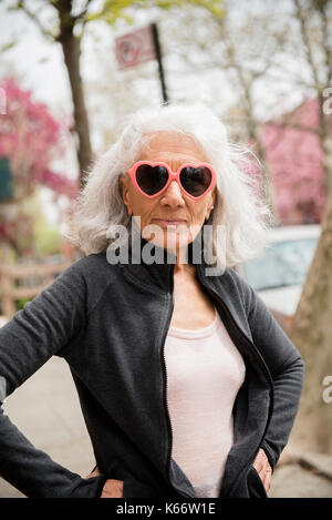 Ältere Frau Herzen tragen - Form Sonnenbrille Stockfoto