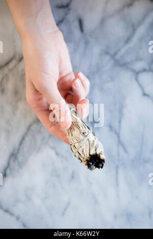 Hand der kaukasischen Frau mit einem Ritual Räucherstäbchen Stockfoto