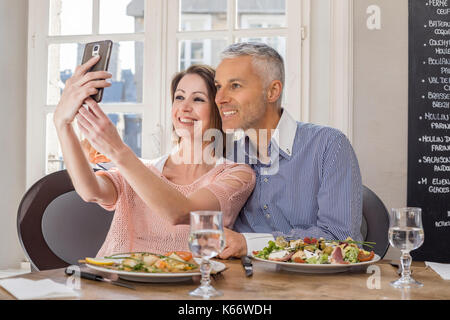 Kaukasische Paar für Handys posing selfie im Restaurant Stockfoto