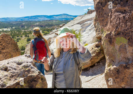 Kaukasische Großmutter wandern mit Enkelin in der Nähe von Felsen Stockfoto