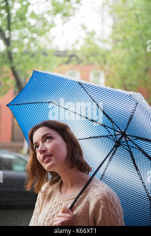 Kaukasische Frau mit Regenschirm suchen Stockfoto