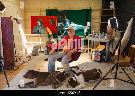 Portrait von älteren kaukasischen Mann in Workshop mit Hunde Stockfoto