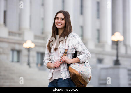 Lächelnd kaukasische Frau, die Rucksack in der Schule Stockfoto