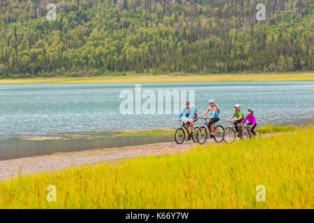 Paar mit Sohn und Tochter auf dem Fahrrad in der Nähe des Sees Stockfoto