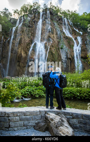 Ältere kaukasischen Paar umarmen in der Nähe von Wasserfall Stockfoto