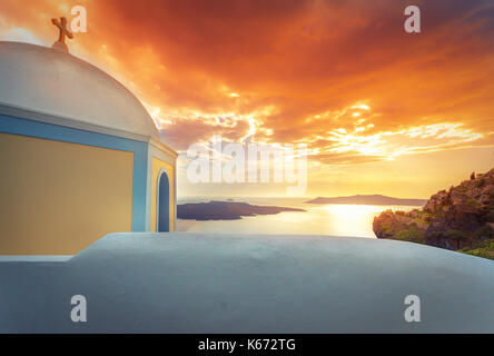 Blick am Abend von Fira, Caldera, Vulkan von Santorini, Griechenland mit Kreuzfahrtschiffen bei Sonnenuntergang. Dramatischer Wolkenhimmel. Stockfoto