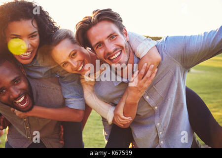 Zwei lachen Paare Huckepack im Freien, in der Nähe Stockfoto