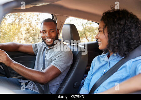 Junge schwarze Paar in einem Auto sich einander lächelnd Stockfoto