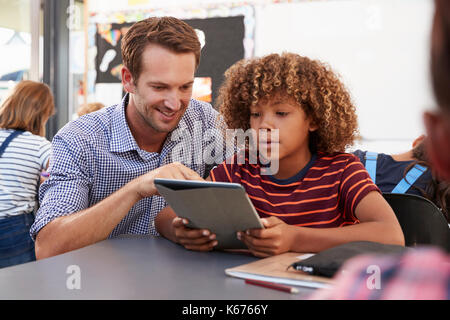 Lehrer und Schüler mit Tablet-PC in der Klasse Stockfoto