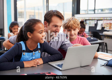 Lehrer und zwei junge Studenten Laptop-Computer in der Klasse Stockfoto