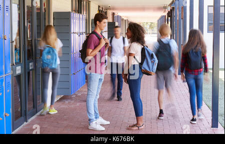 Teenage classmates stand sprechen in der Schule Flur Stockfoto