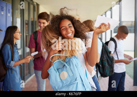 Zwei Mädchen feiern Prüfungsergebnisse in der Schule Korridor Stockfoto