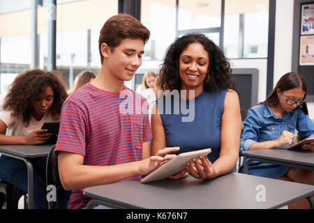 Lehrer helfen Jugendlichen Schüler mit Tablet-PC Stockfoto