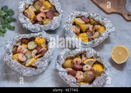 Hausgemachte, traditionelle Cajun Shrimp Kochen mit Wurst Kartoffel und Mais foil Pack Stockfoto