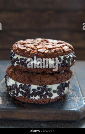 Hausgemachtes Vanilleeis Sandwiches mit Schokolade tropfen Cookies auf dunklem Hintergrund Stockfoto