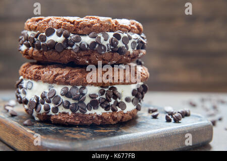 Hausgemachtes Vanilleeis Sandwiches mit Schokolade tropfen Cookies auf dunklem Hintergrund Stockfoto
