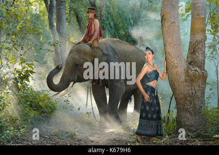 Frau, die traditionelle thailändische Bekleidung mit einem mahout, ein Elefant, Thailand Stockfoto