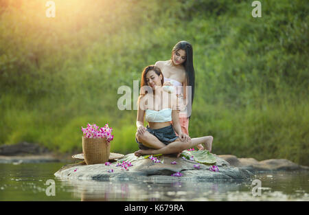 Frau ihrem Freund eine Massage durch den Fluss, Thailand, Stockfoto