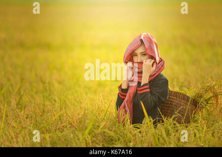 Porträt einer Frau, die in einem Feld, Thailand Stockfoto