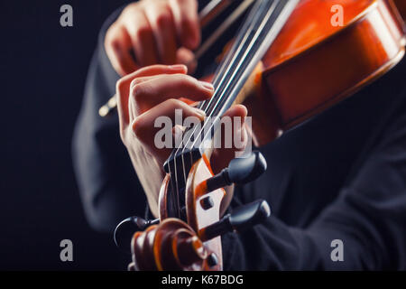 Violine zu spielen. Musikinstrument mit Interpret Hände auf dunklem Hintergrund Stockfoto