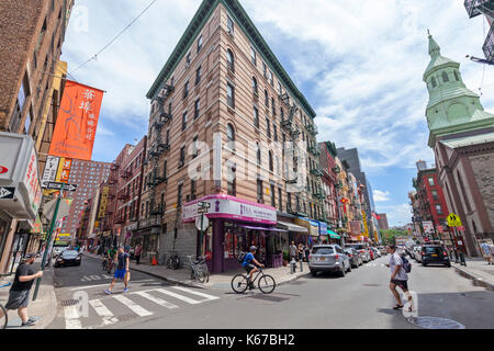 Fußgänger laufen und die Straße in Chinatown, New York City. Stockfoto