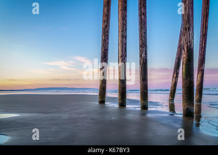 Anzeigen der Sonne über dem Pazifischen Ozean unter vom Pier in Pismo Beach, Kalifornien, USA Stockfoto