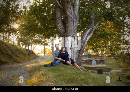 Ein Mann und eine Frau sitzen auf dem Friedhof Blick auf die Grabsteine. Stockfoto