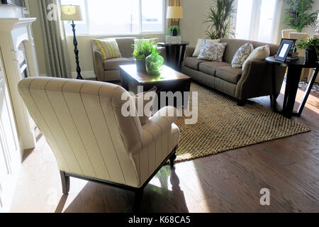 Ein eingerichtetes Wohnzimmer mit Bücherregalen, eine Couch, Sessel und einen Tisch. Stockfoto