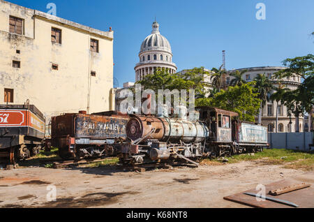 Schrottplatz hinter dem berühmten National Capitol Gebäude in der Innenstadt von Havanna, der Hauptstadt von Kuba, mit verlassenen, rostenden Eisenbahn Lokomotive Motoren Stockfoto