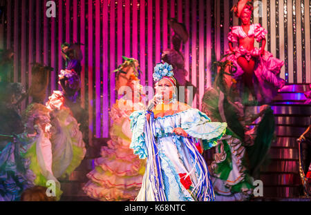 Sänger und exotische Tänzer singen und spielen live auf der Bühne in bunten Kostümen in einem Cabaret Show für Touristen in einem Nachtclub in Havanna, Kuba Stockfoto