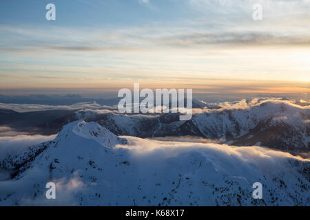 Schöne Antenne Landschaft, Blick auf die Berge in Wolken bei Sonnenuntergang. Bild nördlich von Vancouver, British Columbia, Kanada. Stockfoto
