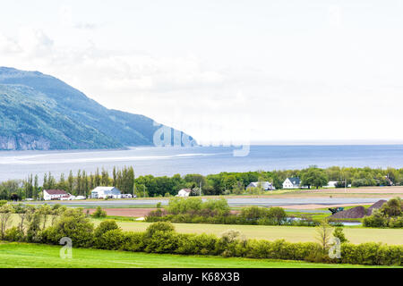 Antenne Stadtbild Landschaft Blick auf Ackerland in Ile d'Orleans, Quebec, Kanada mit St. Lawrence River, Feld, Furchen, Bauernhöfe, Häuser, Hügel und Villa Stockfoto