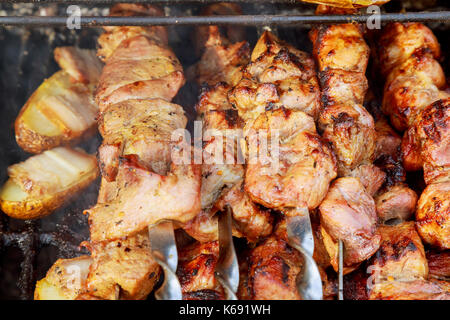 Der Rauch steigt über die gebratenen Fleisch auf die Spieße auf den Kohlen. Shish Kebab, Grill, Schwein. Stockfoto