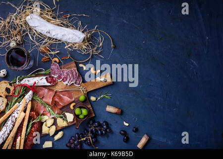 Wurst Snacks auf Holz Hintergrund. Salami und Käse serviert mit Rotwein. Ansicht von oben, kopieren. Stockfoto