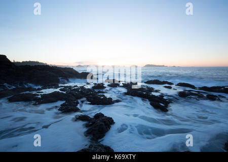 Schönen winter Sonnenaufgang am felsigen Pacific Ocean Shore. Bild in Amphitrite Point Lighthouse, Ucluelet, Vancouver Island, British Columbia, Stockfoto