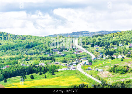 Les Eboulements, Charlevoix, Quebec, Kanada Stadtbild oder Skyline mit Haupt Highway, der steile kurvige Straße senkrecht nach oben gehen, patch Farm green Löwenzahn fi Stockfoto