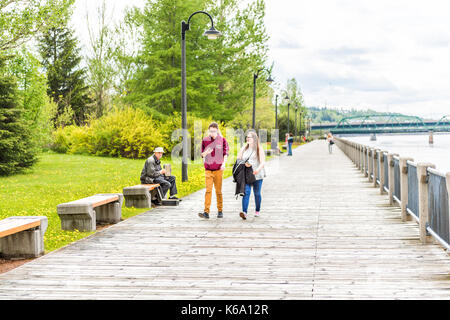 Saguenay, Kanada - Juni 3, 2017: Terrasse Promenade in der Innenstadt von Sommer City Park in Québec mit dem Musiker spielen Akkordeon und junges Paar wa Stockfoto