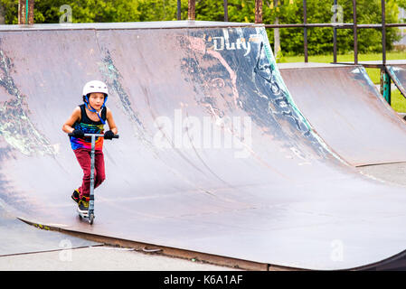 Saguenay, Kanada - Juni 3, 2017: Downtown City Sommer Park in Quebec mit junger Teenager boy Skaten, Tricks, Stunts auf Roller, Reiten auf Stockfoto